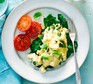 Scrambled eggs with basil, spinach & tomatoes on a plate