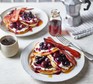 Pancakes with cherries, bacon and mascarpone on plate.