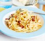 Carbonara with chicken and pancetta on a plate with fork