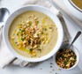Celeriac soup in a bowl topped with toasted hazelnut crumble