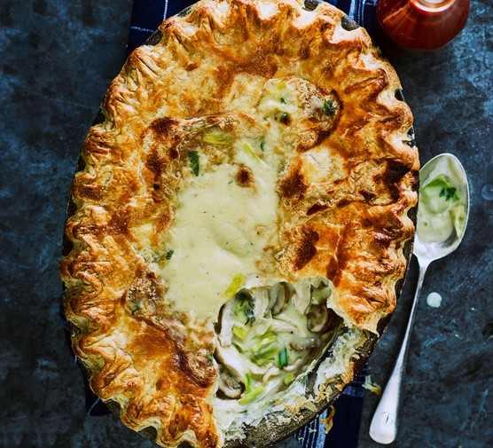 Chicken and leek pie with a crimped pastry top with a spoon taken out