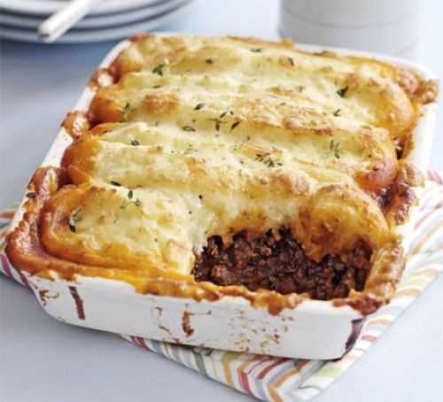 Cottage pie with spoonful taken out in a square casserole dish