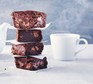 Stack of gluten-free chocolate brownies next to a mug