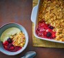 Gluten-free mixed berry crumble served with custard