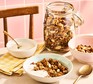 Healthy homemade granola in a jar alongside a bowl