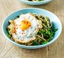 A bowl of wholemeal noodles with vegetables and fried eggs