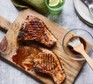 Quick honey & garlic pork chops on a wooden serving platter
