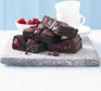 A pile of chocolate raspberry brownies on a board