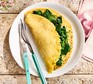 Vegan chickpea flour omelette filled with spinach on a white plate